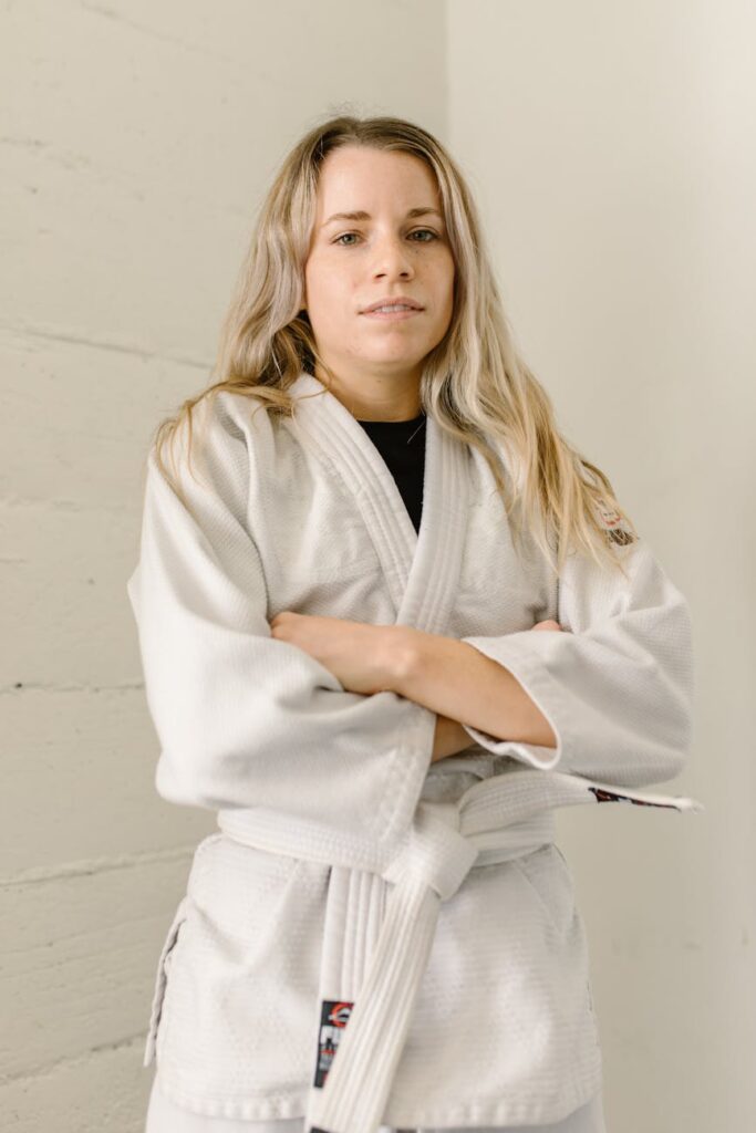 a woman in taekwondo uniform with her arms crossed